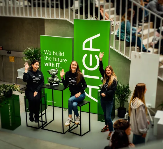 Atea employees at a technology recruitment event, welcoming attendees at a branded booth promoting careers in IT and digital innovation.