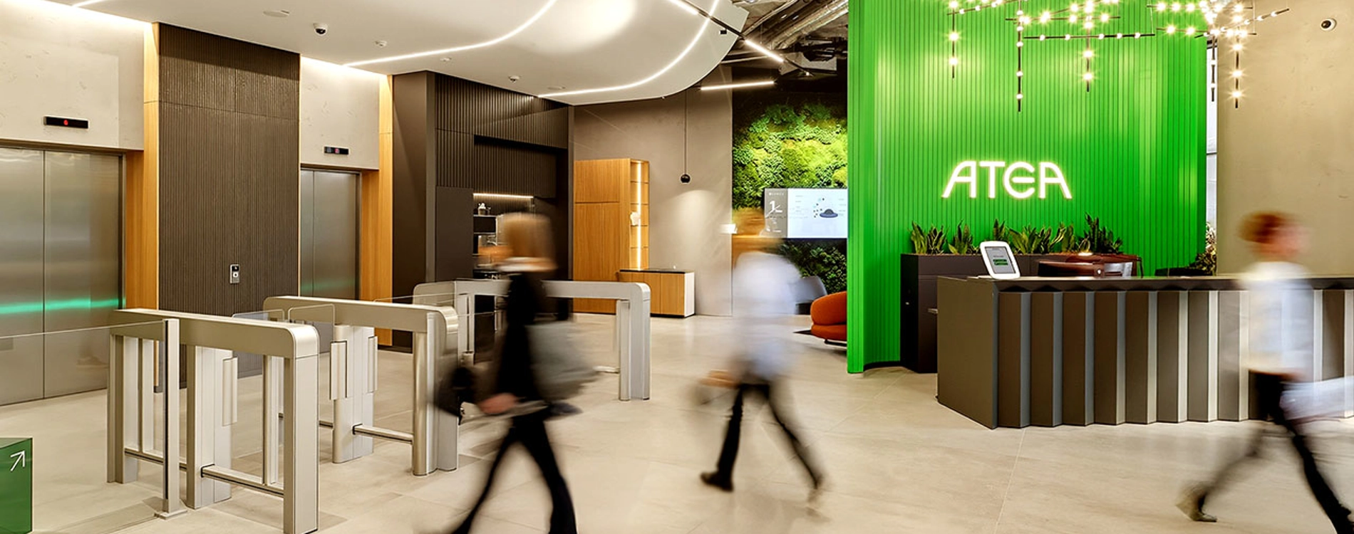 Modern Atea office entrance with reception desk and people walking through the space.